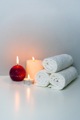 Natural health in SPA concept photo, vertical orientation. White towels and candle lights.