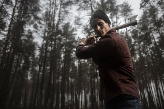 Lumberjack with the ax in the forest.Stylish lumberman getting ready for work. Hard iwork in the forest. Lumberjack chopping a tree. Lifestyle. 