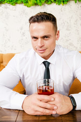 Businessman drinks whiskey at the table
