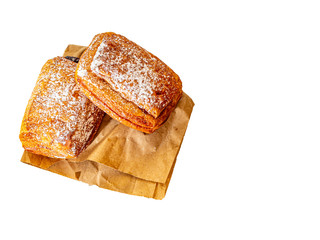 Buns with condensed milk and sprinkled with powdered sugar on a white background.