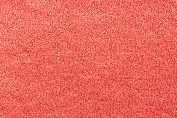 The texture of the terry towel is coral color. Abstract red soft fabric background.