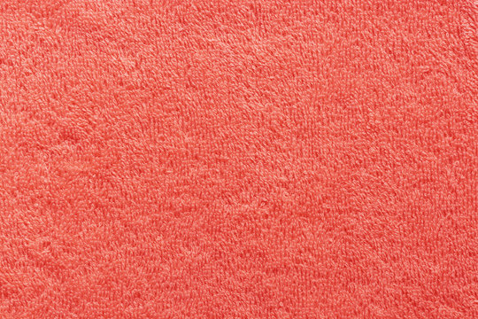 The texture of the terry towel is coral color. Abstract red soft fabric background.