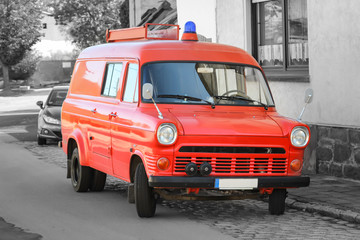 ein altes ehemaliges Feuerwehrauto steht am Straßenrand