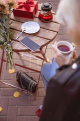 Young woman drinking tea in the street cafe