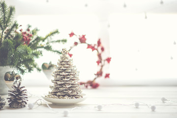 Christmas, holidays and eating concept -table for festive dinner. Christmas decorations with window light behind it, creating a nice blurry boken.