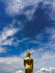 Golden Buddha statue at Wat Phra That Kao Noi with colorful clouds sky in morning, Nan Province, Thailand