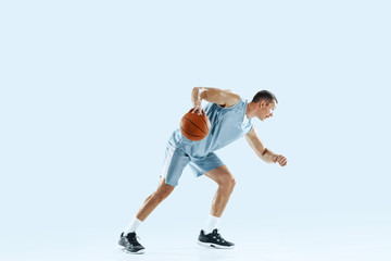 Winner. Young caucasian basketball player of team in action, motion in jump isolated on blue background. Concept of sport, movement, energy and dynamic, healthy lifestyle. Training, practicing.