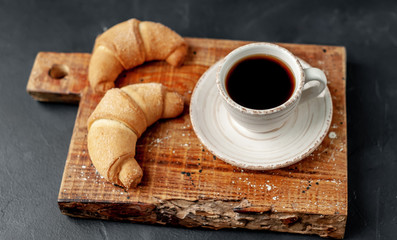 Coffee and croissants on a stone background. delicious morning breakfast