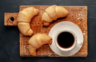 Coffee and croissants on a stone background. delicious morning breakfast