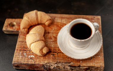 Coffee and croissants on a stone background. delicious morning breakfast