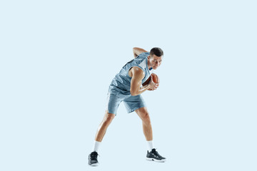 Winner. Young caucasian basketball player of team in action, motion in jump isolated on blue...