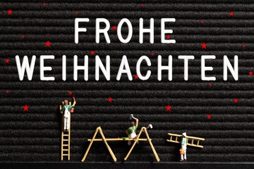 little painter figures in front of letter board with German 