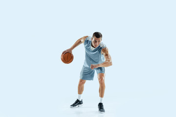 Winner. Young caucasian basketball player of team in action, motion in jump isolated on blue background. Concept of sport, movement, energy and dynamic, healthy lifestyle. Training, practicing.