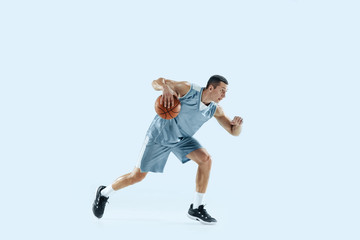 Fototapeta na wymiar Winner. Young caucasian basketball player of team in action, motion in jump isolated on blue background. Concept of sport, movement, energy and dynamic, healthy lifestyle. Training, practicing.