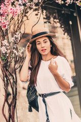 Fototapeta premium Beautiful woman posing for the camera near flower composition.