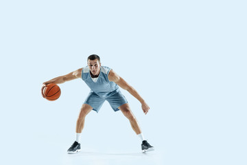 Plakat Champion. Young caucasian basketball player of team in action, motion in jump isolated on blue background. Concept of sport, movement, energy and dynamic, healthy lifestyle. Training, practicing.