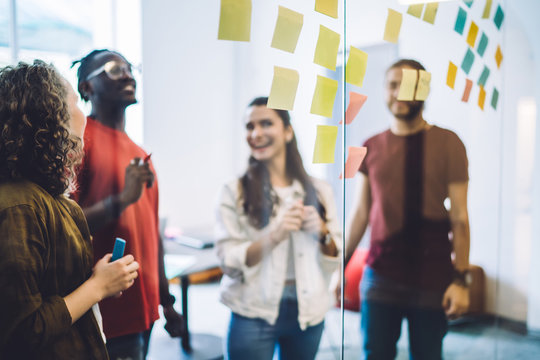 Laughing students against wall with colorful notes