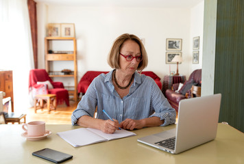 Middle age senior woman working at home using computer