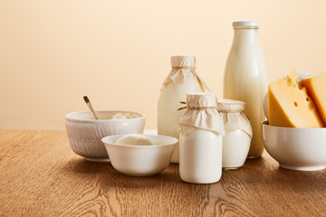 tasty organic dairy products on rustic wooden table isolated on beige