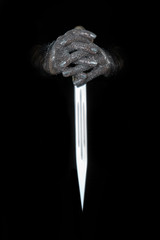 beautiful woman hands with glitter holding a sword close up