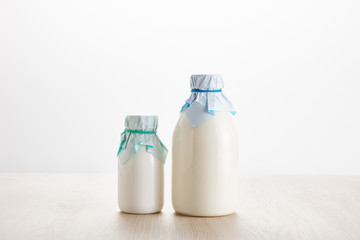 various fresh organic dairy products in bottles on wooden table isolated on white