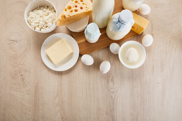 top view of various fresh organic dairy products and eggs on wooden table