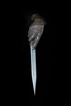 beautiful woman hands with glitter holding a sword close up