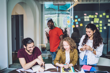 Young smiling friends coworking in office