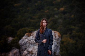Asian young woman tourist wearing coat in view of mountain against fall forest