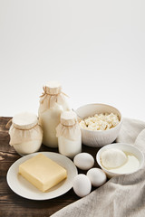 delicious fresh dairy products and eggs on rustic wooden table with cloth isolated on white