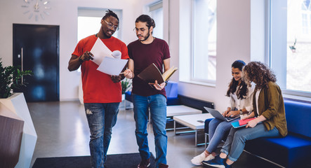 Communicating students in modern hallway