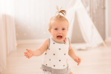Fototapeta premium baby girl in the nursery playing,bright children's room, textiles for children's room