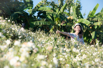 Pretty girl enjoying in a field with field flowers and smiles sincerely, Copy space