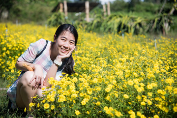 Fototapeta premium Pretty girl enjoying in a field with field flowers and smiles sincerely, Copy space