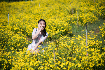 Fototapeta premium Pretty girl enjoying in a field with field flowers and smiles sincerely, Copy space