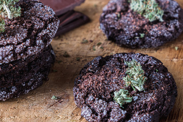 chocolate chip cookies with marijuana, sprinkled with chocolate chips and cannabis, are on a slate dish.