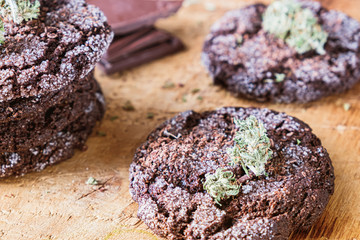 chocolate chip cookies with marijuana, sprinkled with chocolate chips and cannabis, are on a slate dish.