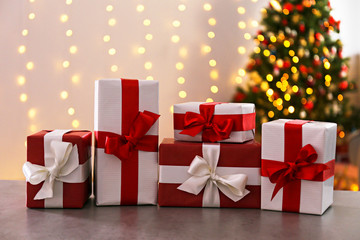 Traditional christmas pine tree with holiday decorations on background and stack of presents on...
