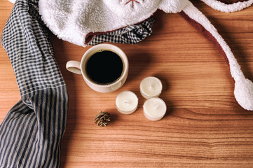 Coffee in the winter are decoration with scarf, hat, candles and pine on the wooden table. Warm color tone. Top view.