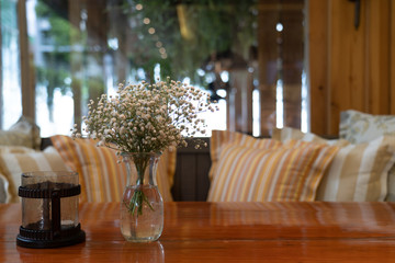 Bouquet of dried flowers in a glass vase is placed on the table in a coffee shop