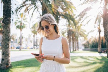 Smiling woman using phone on street