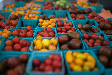 Pint baskets of organic red tomatoes on the counter at a farmer's market. Fresh produce on sale at the local farmers market.
