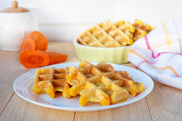 Carrot honey waffles served on white plate. 