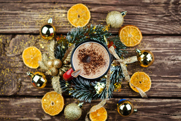 Christmas composition. Red Cup with cappuccino coffee over wooden background. Close-up with space for text.