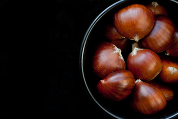 Edible chestnuts in a black bowl.