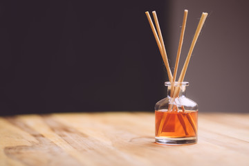 Air fragrance in the form of liquid and wooden sticks on a wooden table