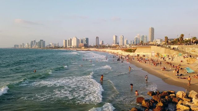 Tel Aviv Jaffa Yafo beach life in the Mediterranean Sea in the golden hour with skyline, 4k video