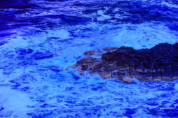 The ocean crashing on rocks with white waves in Kiama New South Wales taken in Infrared