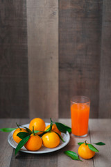 The fresh juice of citrus fruits on the wooden background. Close up