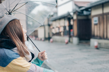 Lonely woman  with umbrella is waiting for the rain on the street  in Japan.